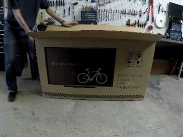 Set Ebike box upright, remove strapping, cut open along top edge.