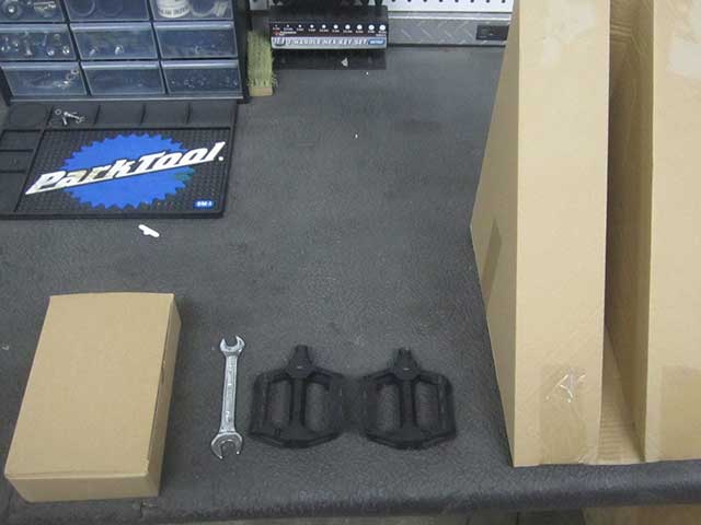Inside the triangular shaped box you will find your pedals, a pedal wrench, and charger.