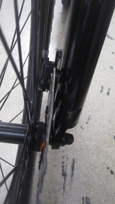 12. Gently insert wheel into fork . Carefully slide the disc brake rotor into the disc brake pads. Make sure wheel is on fork as far as it will go. Tighten the locknut, until the quick release fully tightens the axle onto the fork. You want the quick release to close snugly, but you don’t want to overtighten it. You don’t want to have to “muscle” the quick release to close it, should close firmly, but without excessive force.